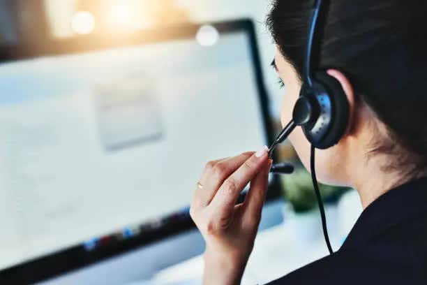 Support agent on a headset call at her workstation